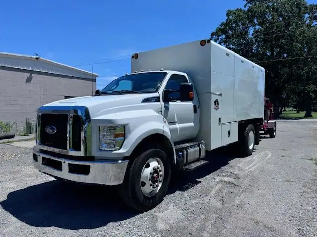 A white Ford chip truck with a tall box body