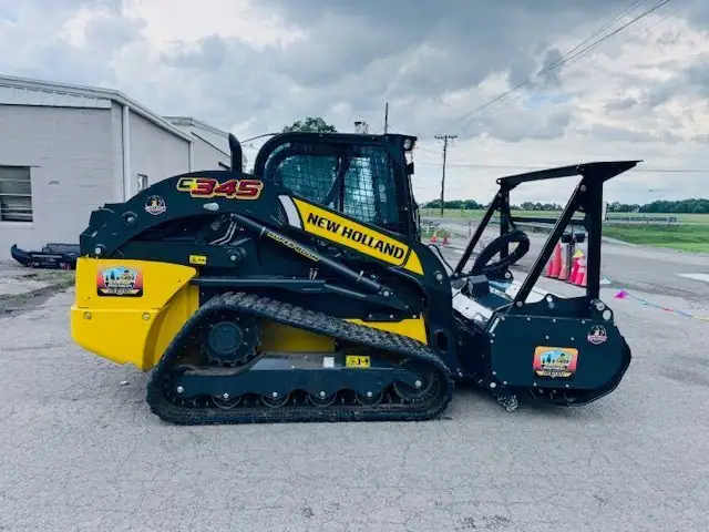 A New Holland tracked loader with a forestry mulcher attachment